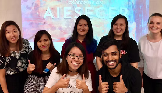 AIESEC NTU members smiling together in front of a Become an AIESECer presentation